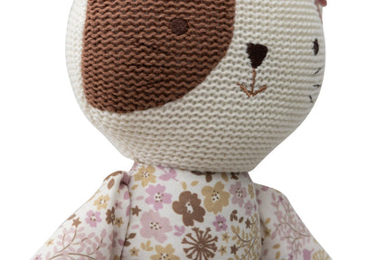 Zbliżenie na jasny pyszczek kota z brązową łatką oraz haftowanym nosem i wąsami.