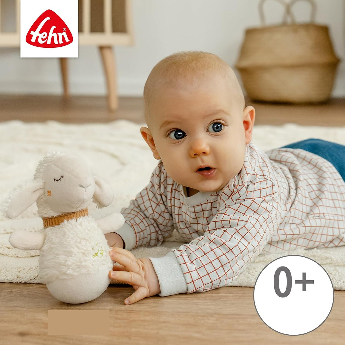 Beżowa owca FEHN obok dziecka leżącego na brzuchu na macie.